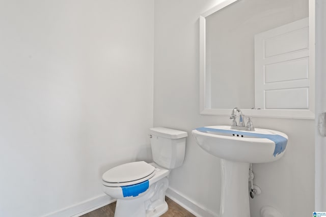 bathroom featuring hardwood / wood-style flooring and toilet