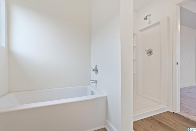 bathroom featuring wood-type flooring and separate shower and tub