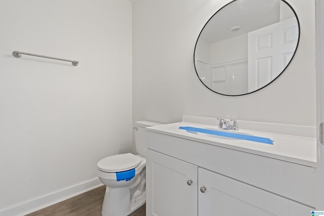 bathroom featuring hardwood / wood-style flooring, vanity, toilet, and walk in shower