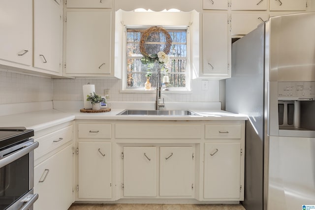 kitchen featuring appliances with stainless steel finishes, sink, decorative backsplash, and white cabinets