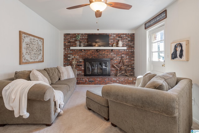 carpeted living room with a brick fireplace and ceiling fan