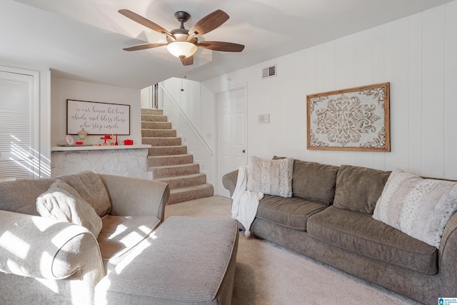 carpeted living room with ceiling fan