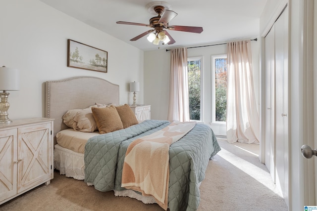 carpeted bedroom with ceiling fan and a closet