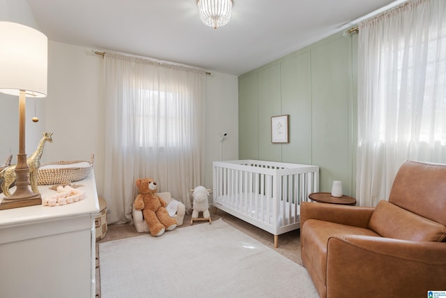 carpeted bedroom featuring a crib