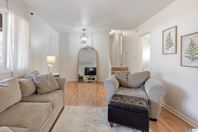 living room with an inviting chandelier and light hardwood / wood-style floors