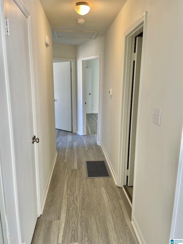 corridor with light hardwood / wood-style flooring