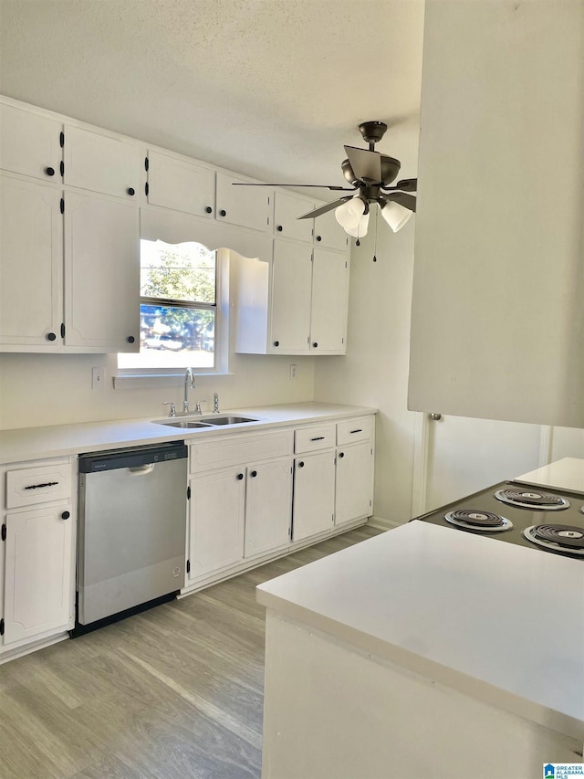 kitchen with sink, stainless steel dishwasher, white cabinets, and light hardwood / wood-style flooring