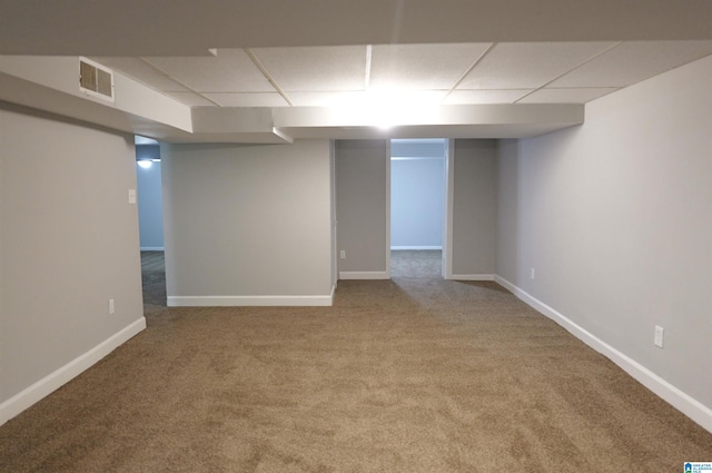 basement with a paneled ceiling and carpet floors