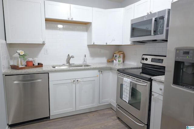 kitchen featuring sink, wood-type flooring, white cabinets, and appliances with stainless steel finishes