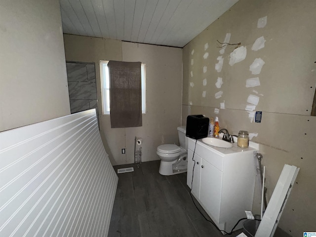 bathroom featuring wood-type flooring, wooden ceiling, vanity, and toilet