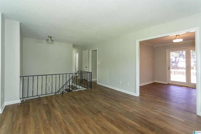 unfurnished room featuring dark hardwood / wood-style flooring, crown molding, and a textured ceiling