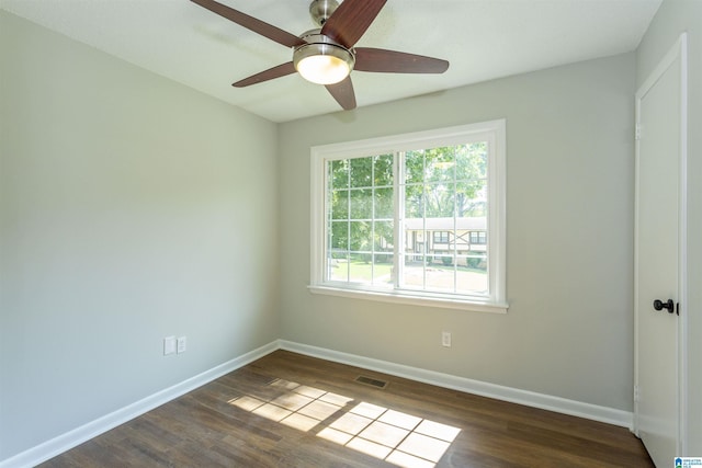 spare room featuring dark wood-type flooring and ceiling fan