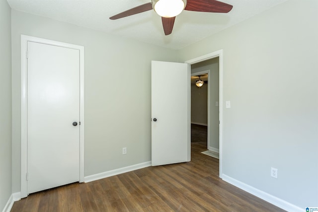 unfurnished bedroom with ceiling fan and dark hardwood / wood-style flooring