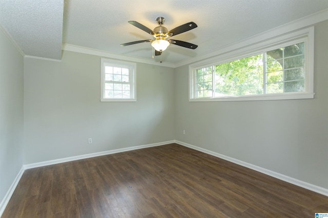 spare room with plenty of natural light, ornamental molding, dark hardwood / wood-style floors, and a textured ceiling