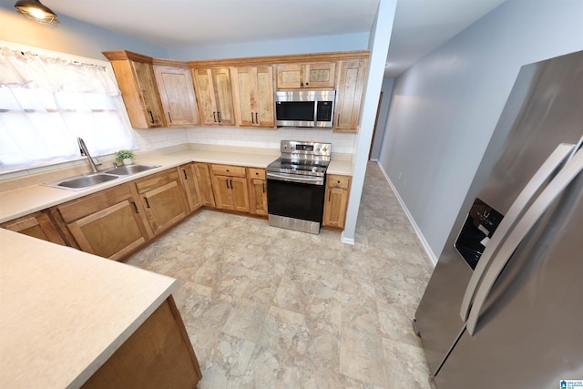 kitchen featuring appliances with stainless steel finishes, sink, and decorative backsplash