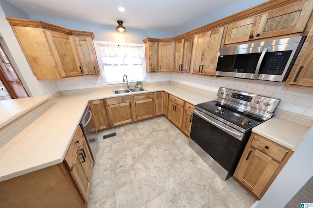 kitchen featuring appliances with stainless steel finishes, sink, and decorative backsplash