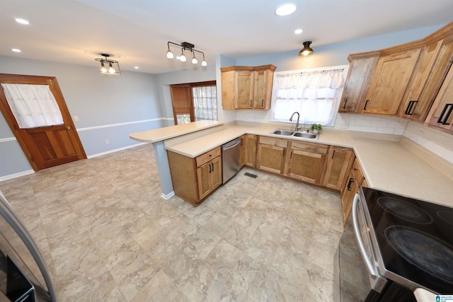 kitchen featuring sink, hanging light fixtures, kitchen peninsula, stainless steel appliances, and decorative backsplash