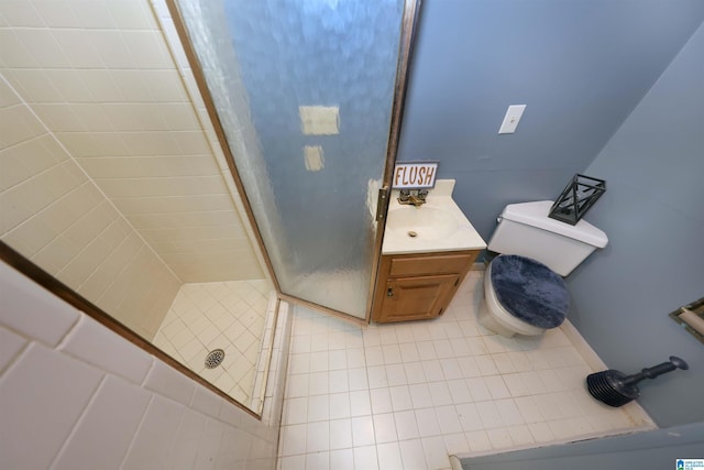 bathroom with vanity, tile patterned flooring, toilet, and a tile shower