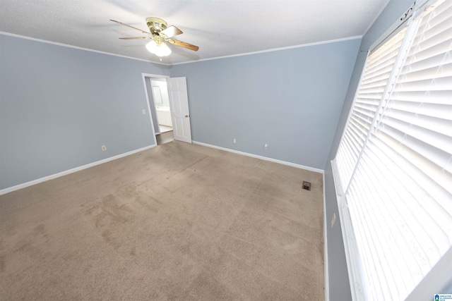 empty room featuring crown molding, light colored carpet, and ceiling fan