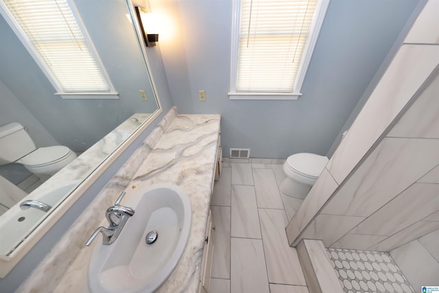 bathroom with vanity, toilet, and plenty of natural light