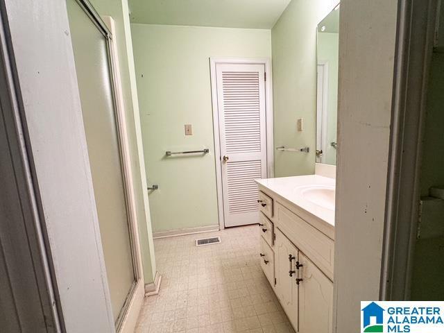 bathroom with walk in shower and vanity