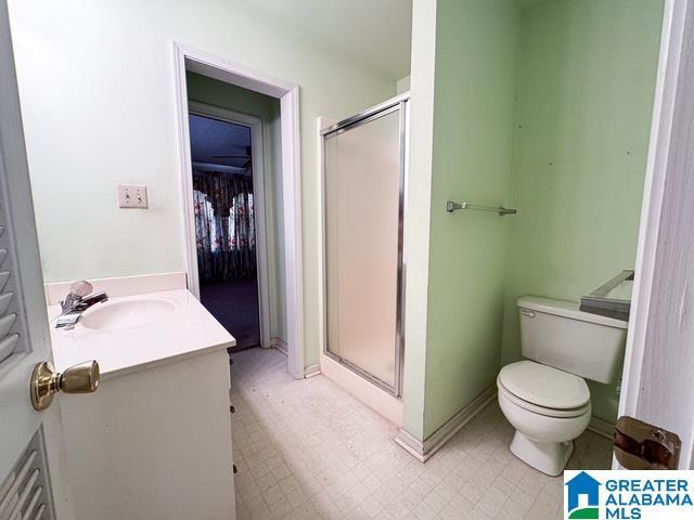 bathroom with vanity, toilet, and an enclosed shower