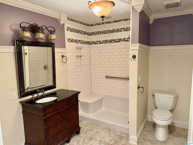 bathroom with vanity, tiled shower, a textured ceiling, and toilet