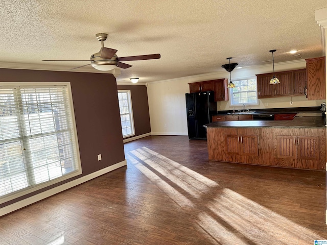 kitchen with pendant lighting, sink, dark wood-type flooring, black appliances, and kitchen peninsula