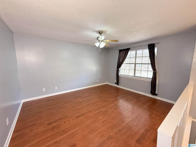 unfurnished room featuring dark wood-type flooring, a textured ceiling, and ceiling fan