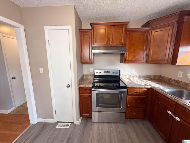 kitchen with sink, hardwood / wood-style floors, electric range, and a textured ceiling