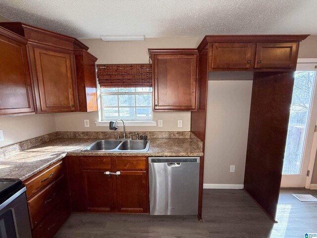 kitchen with appliances with stainless steel finishes, dark hardwood / wood-style flooring, sink, and a textured ceiling