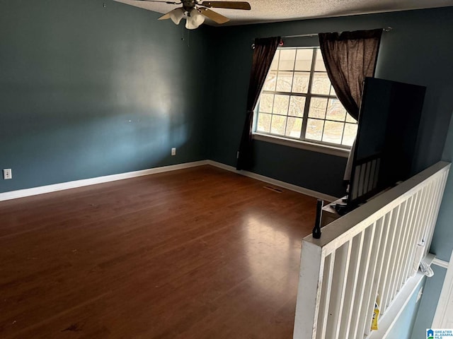 unfurnished room with ceiling fan, hardwood / wood-style floors, and a textured ceiling