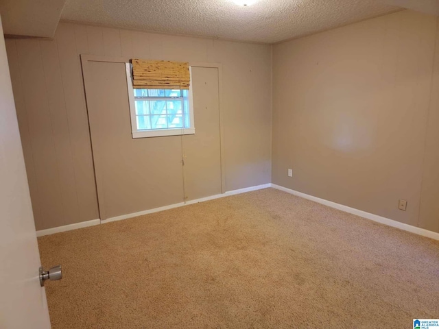 carpeted empty room with a textured ceiling