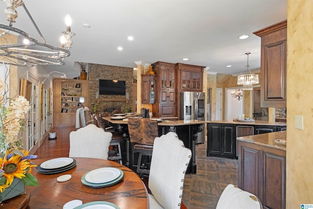 dining space with a large fireplace and an inviting chandelier