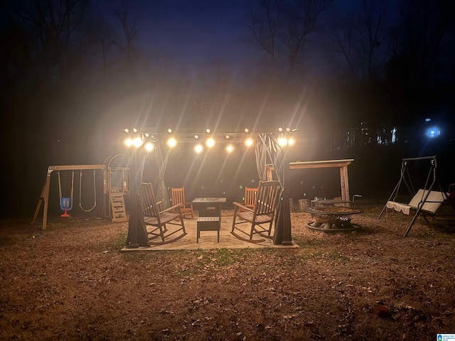 yard at twilight with an outdoor fire pit and a playground