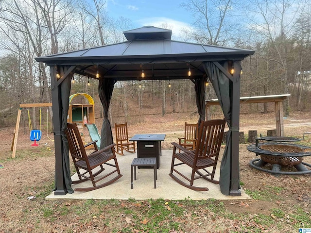 view of patio / terrace featuring a gazebo, a playground, and an outdoor fire pit