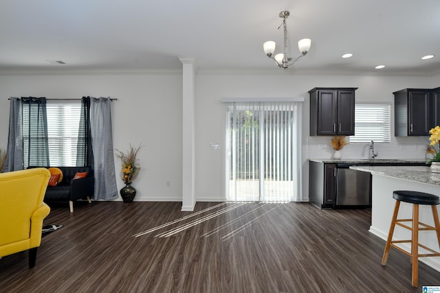 kitchen with dark hardwood / wood-style floors, decorative light fixtures, dishwasher, crown molding, and light stone countertops