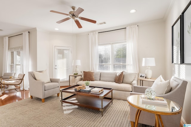 living room with ornamental molding, ceiling fan, and light hardwood / wood-style flooring