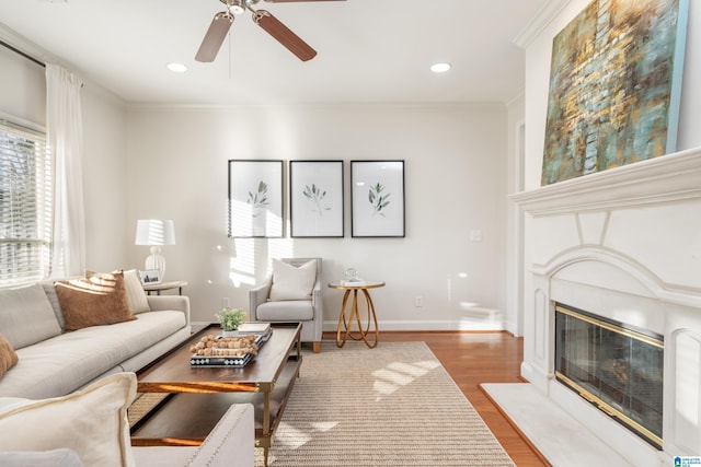 living room featuring crown molding, wood-type flooring, and ceiling fan