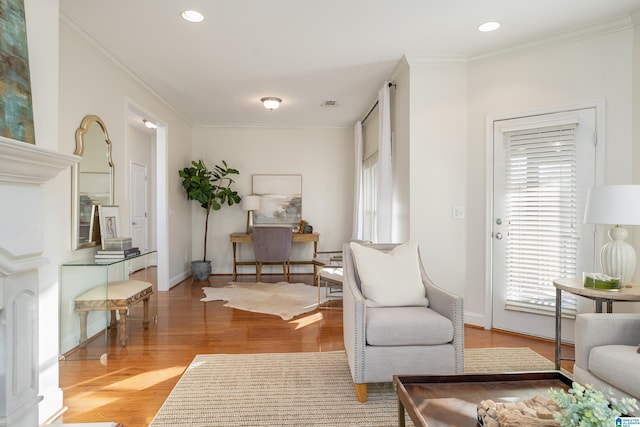 living area with crown molding and light wood-type flooring