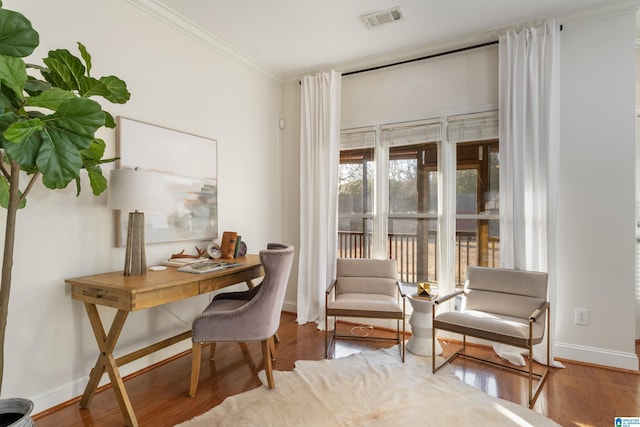 living area with hardwood / wood-style flooring and ornamental molding