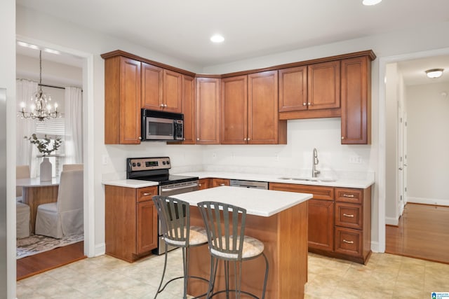 kitchen featuring sink, a kitchen breakfast bar, hanging light fixtures, a center island, and stainless steel appliances