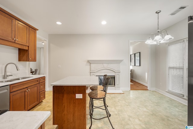 kitchen with sink, decorative light fixtures, a chandelier, a center island, and a kitchen breakfast bar