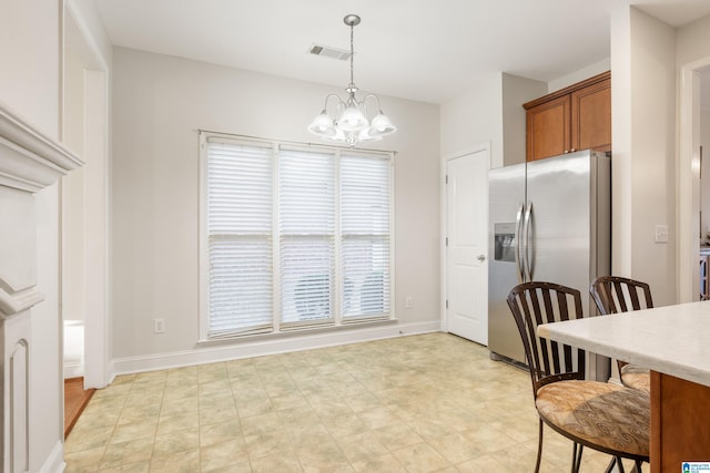 kitchen featuring pendant lighting, stainless steel fridge with ice dispenser, and an inviting chandelier