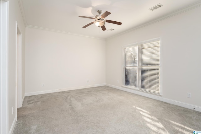 carpeted spare room featuring crown molding and ceiling fan