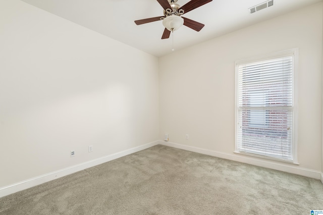 empty room with ceiling fan and light carpet