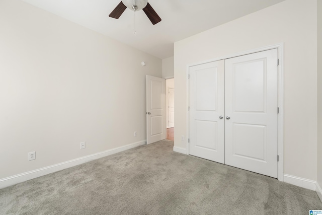 unfurnished bedroom featuring ceiling fan, light colored carpet, and a closet