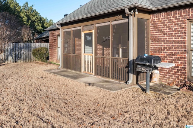 view of side of property featuring a sunroom and a patio area