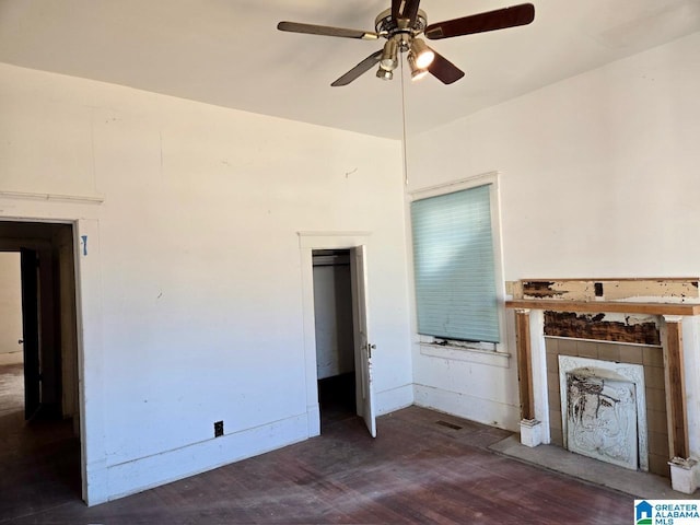 unfurnished living room with dark wood-type flooring and ceiling fan