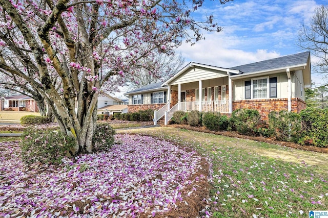 ranch-style home with covered porch and a front yard